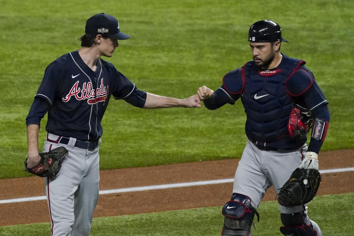 Atlanta Braves pitcher Max Fried and catcher Travis d'Arnaud bump fists after the first inning.