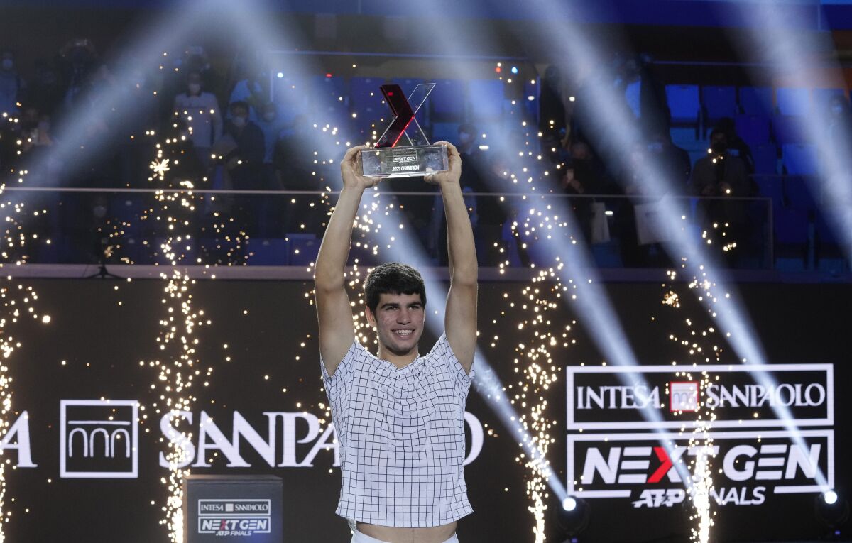 Spain's Carlos Alcaraz holds a trophy after winning the ATP Next Gen final tennis tournament against United States' Sebastian Korda, in Milan, Italy, Saturday, Nov. 13, 2021. (AP Photo/Antonio Calanni)