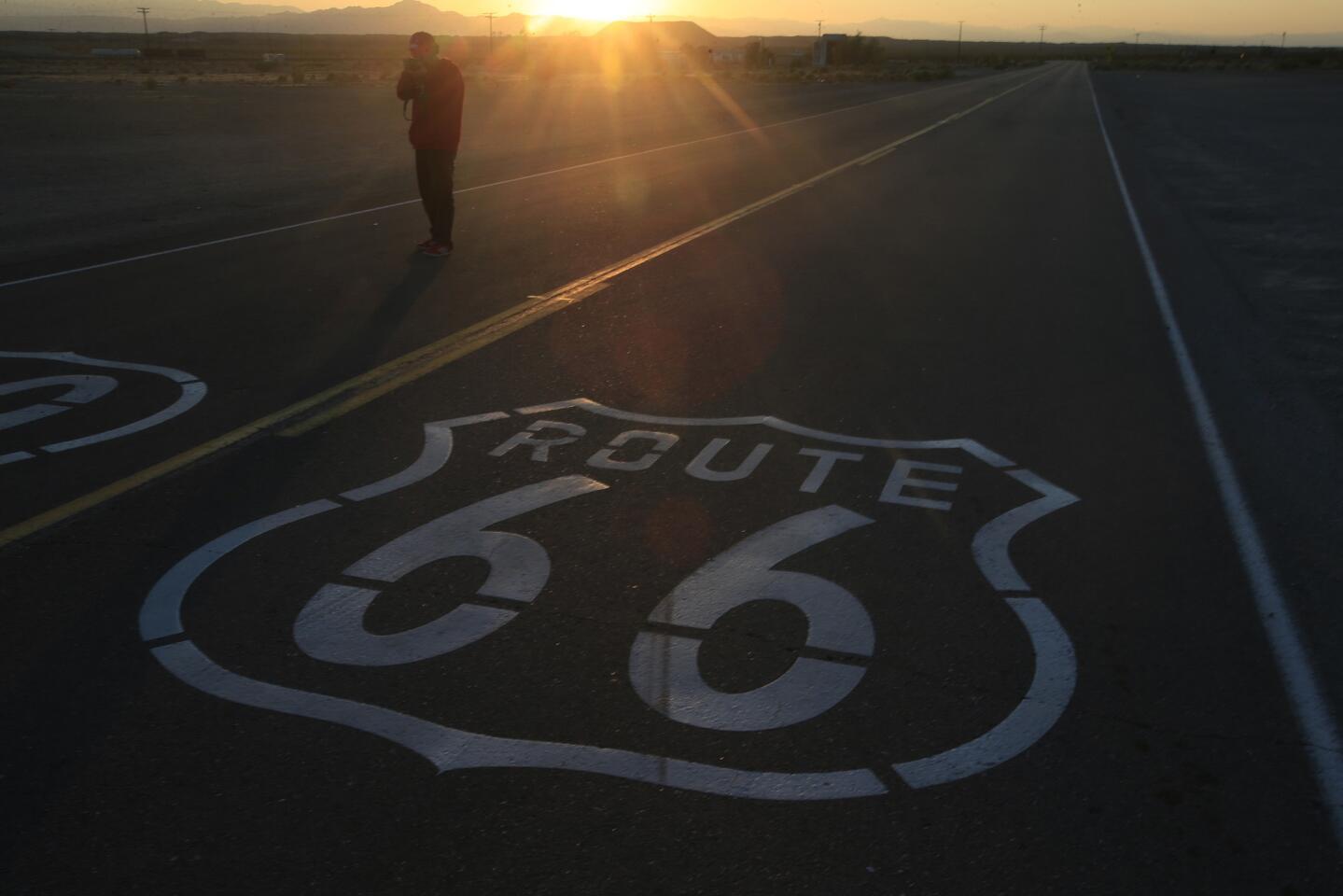 Countless tourists stop for photos of the Route 66 sign painted on the highway in Amboy, Calif.