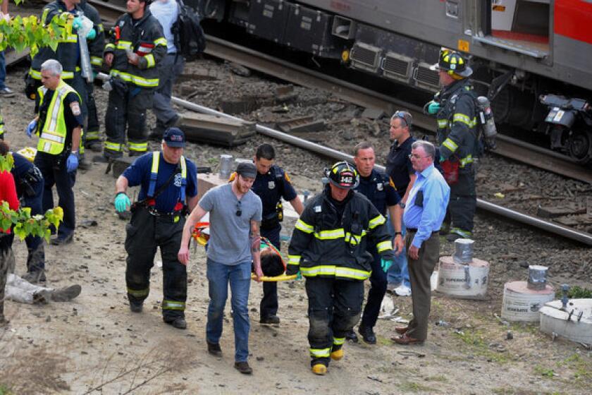 Injured passengers are taken from the site of a collision between two commuter trains near Fairfield, Conn.