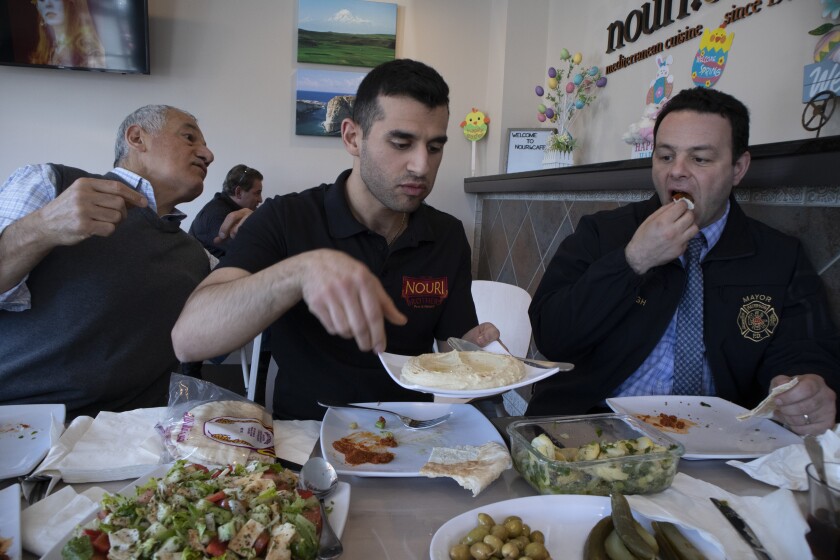 Andre Sayegh, the mayor of Paterson, N.J., right, eats with Albert and George Noury, who own the Nouri Cafe on Main Street in South Paterson. Sayegh is the first Arab American to lead the city.