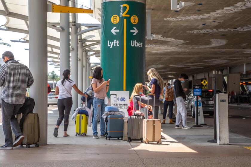 SAN DIEGO, CA - AUGUST 20: People wait for their rideshares to arrive at the San Diego Airport on Thursday, Aug. 20, 2020 in San Diego, CA. (Jarrod Valliere / The San Diego Union-Tribune)
