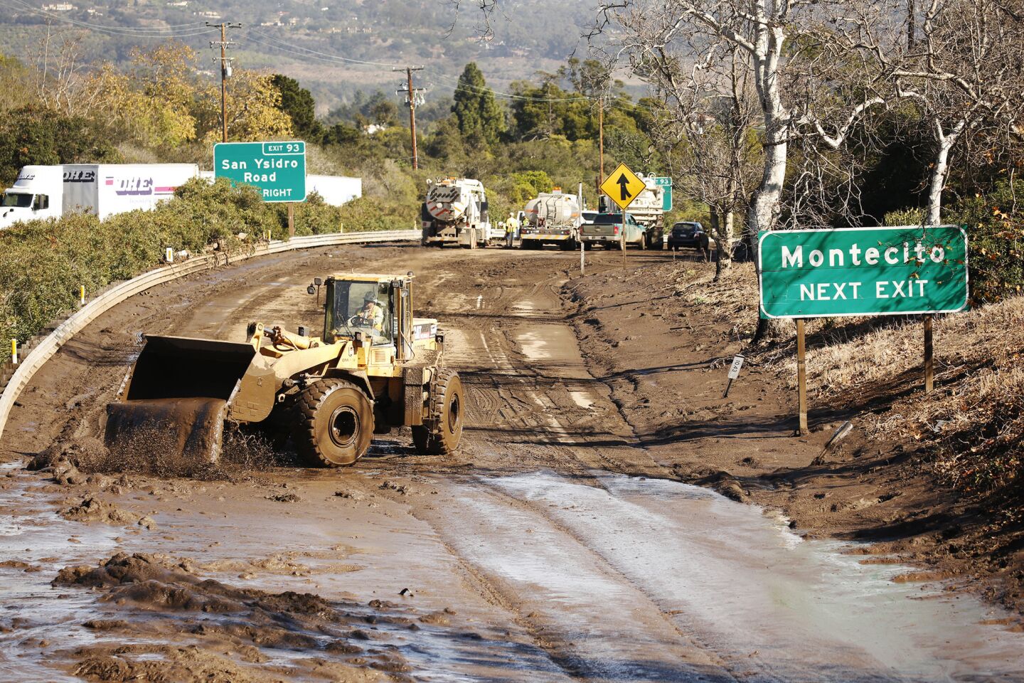 Crews work to clear debris from the closed 101 Freeway at Olive Mill Road in Montecito.
