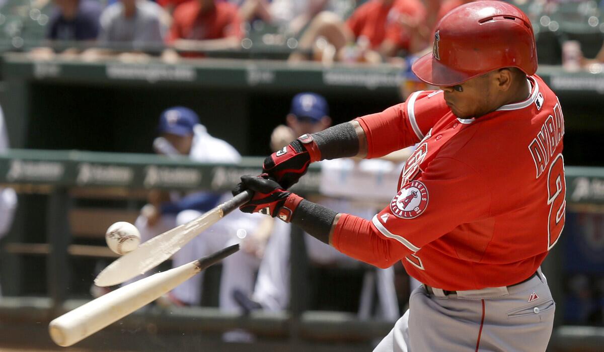 Angels shortstop Erick Aybar breaks his bat while grounding out against the Rangers in the first inning Sunday afternoon.