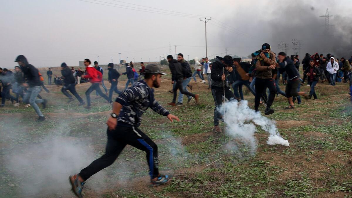 Palestinian protesters on Friday run from tear gas fired by Israeli soldiers east of Gaza City following a protest against President Donald Trump's decision to recognize Jerusalem as the capital of Israel.