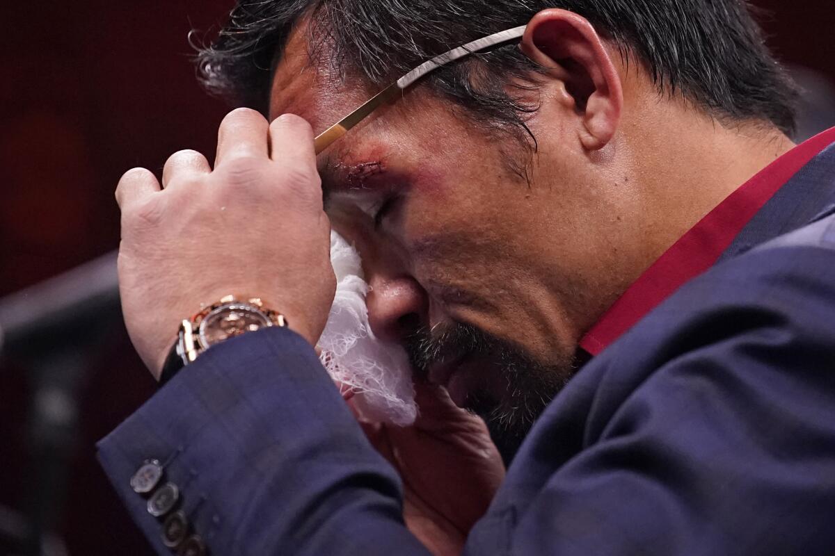 Manny Pacquiao, de Filipinas, se limpia los ojos en conferencia de prensa después de su derrota frente a Yordenis Ugas.