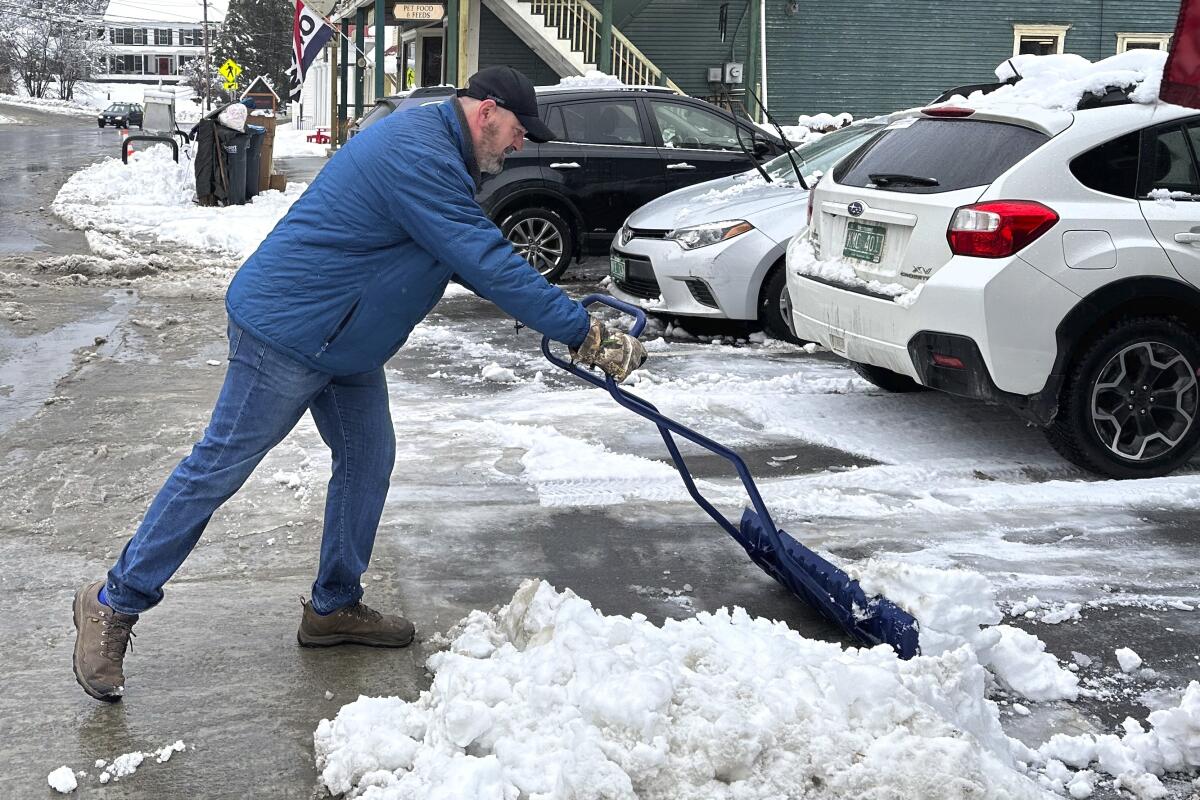 Bobby Searles retira la nieve de un espacio de estacionamiento afuera de la tienda Cabot Village, 