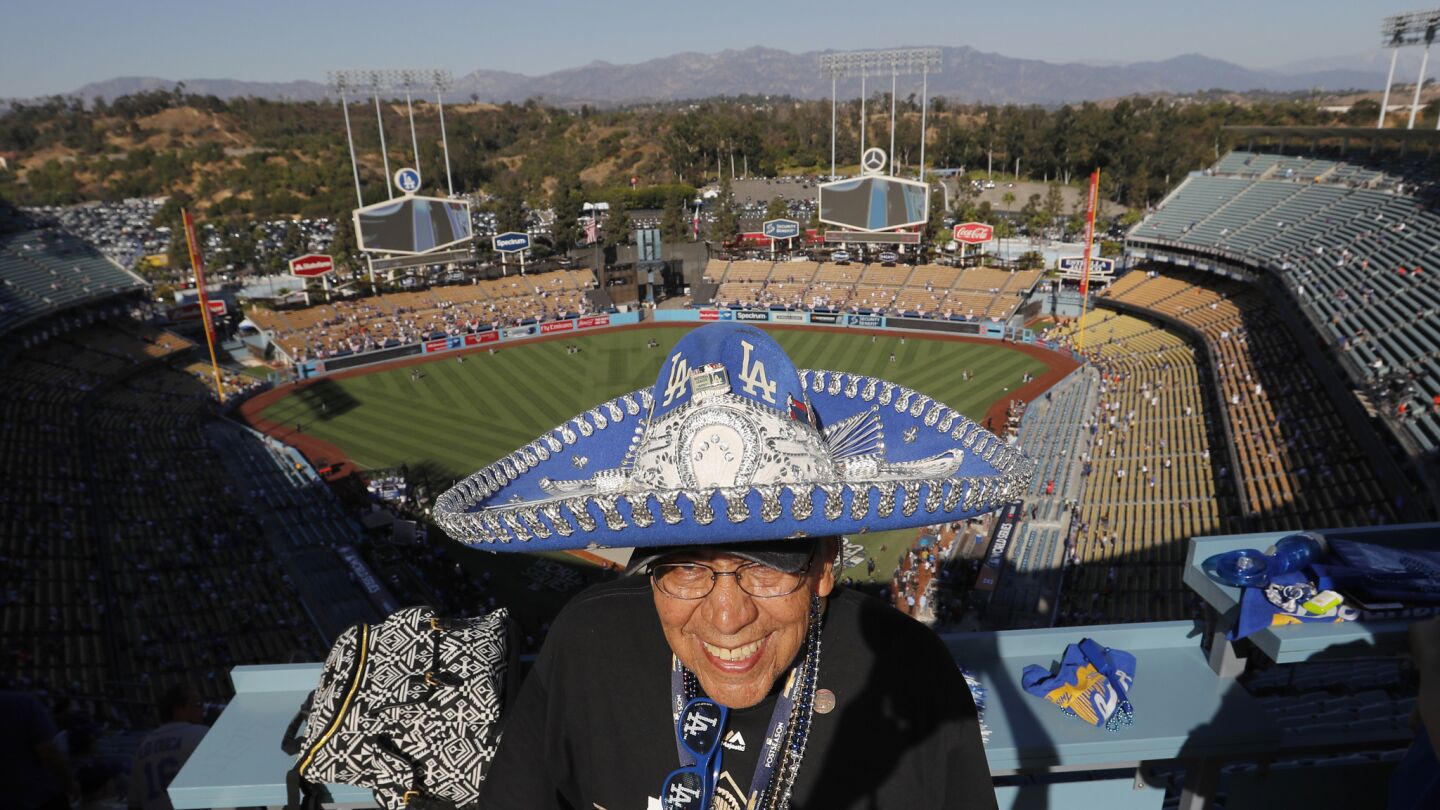Dodgers season-ticket holder Gilbert Romero sports his Dodgers sombrero and beads in upper deck before the start of Game 2.