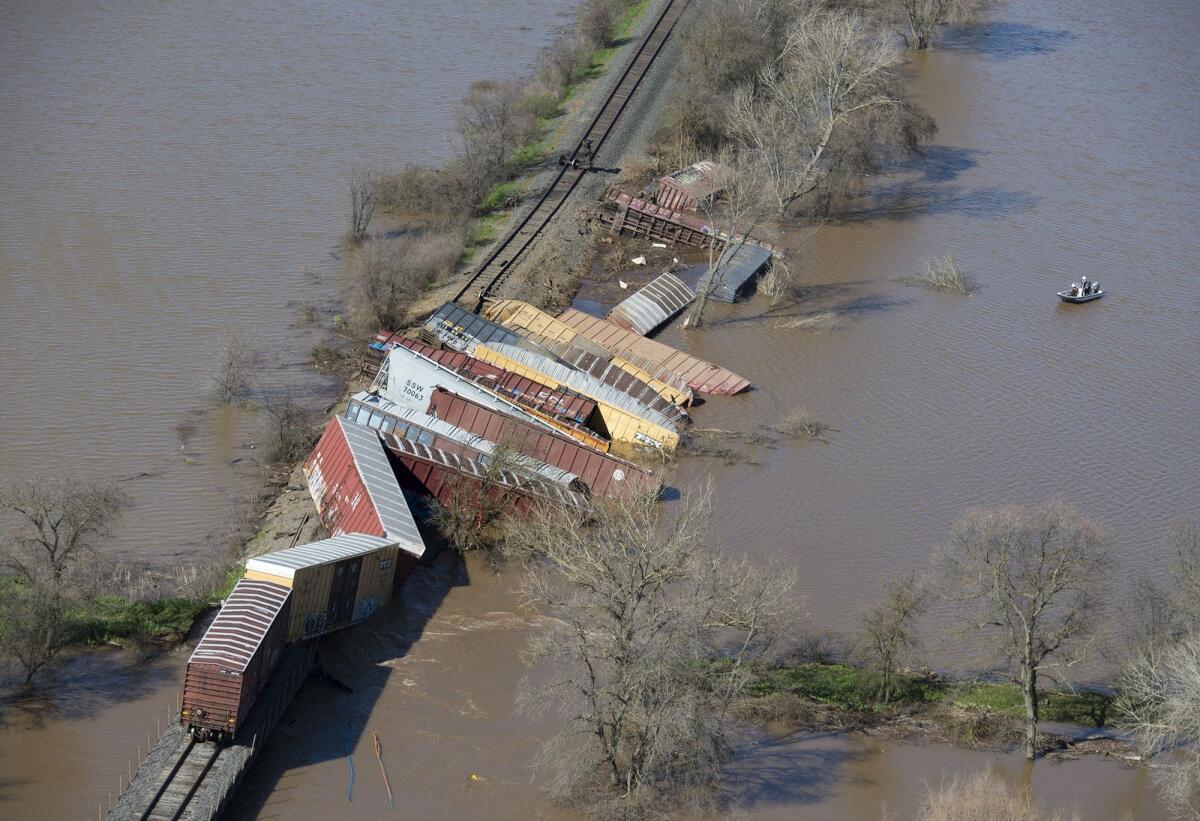 Cars from a freight train derailment lie along the track and in the water of the swollen Cosumnes River on Saturday, near Elk Grove, Calif.