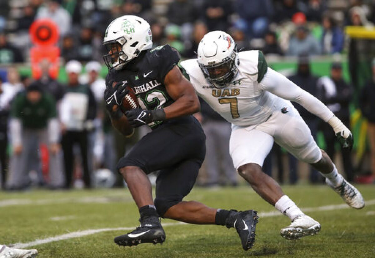 Marshall running back Rasheen Ali (22) attempts to speed past UAB defender Tyler Taylor (7) during an NCAA college football game on Saturday, Nov. 13, 2021, at Joan C. Edwards Stadium in Huntington W.Va. (Sholten Singer/The Herald-Dispatch via AP)