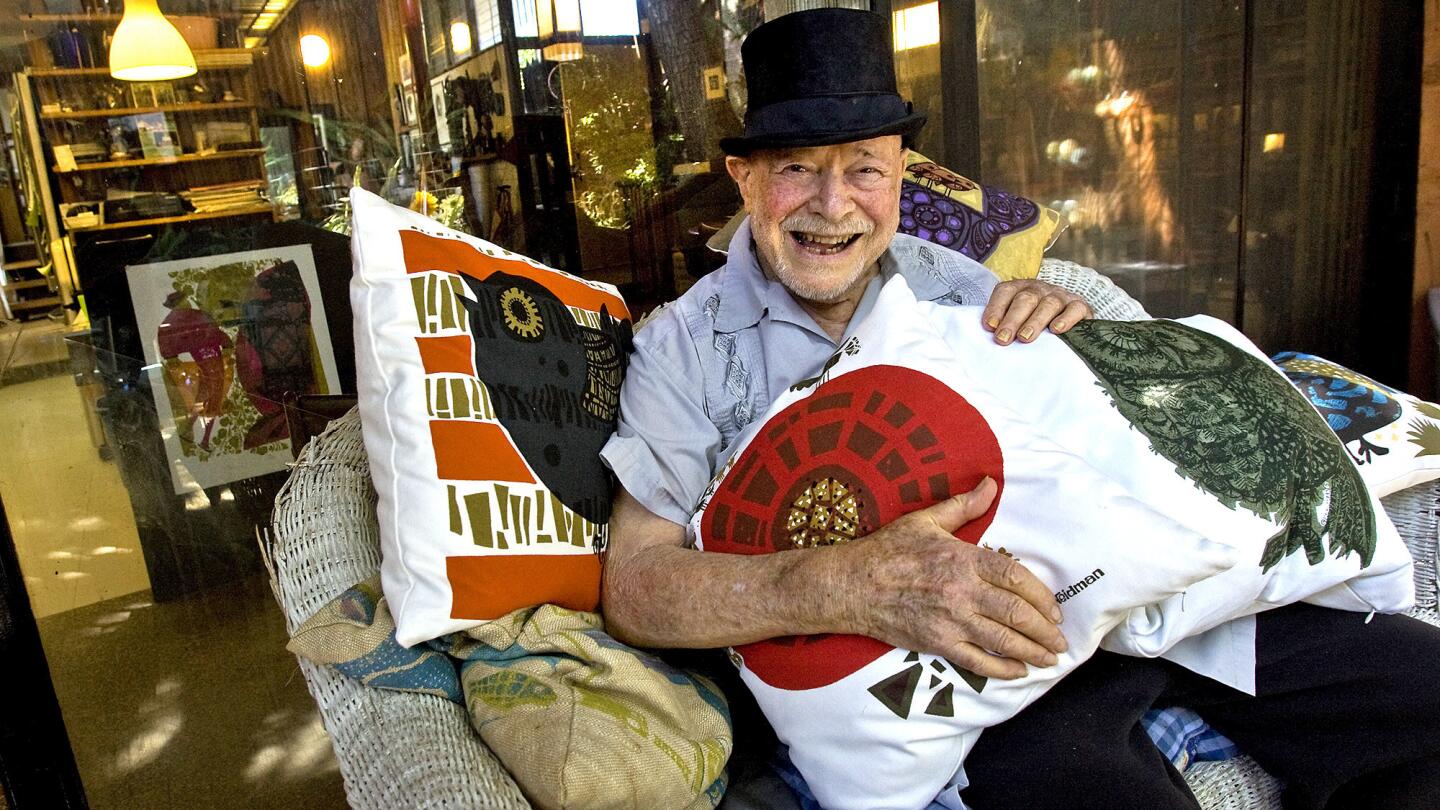 Los Angeles silk-screen artist David Weidman sits on a wicker settee on his patio in July 2010. He is surrounded by a recently launched line of pillows bearing images from his prints sold at Urban Outfitters.