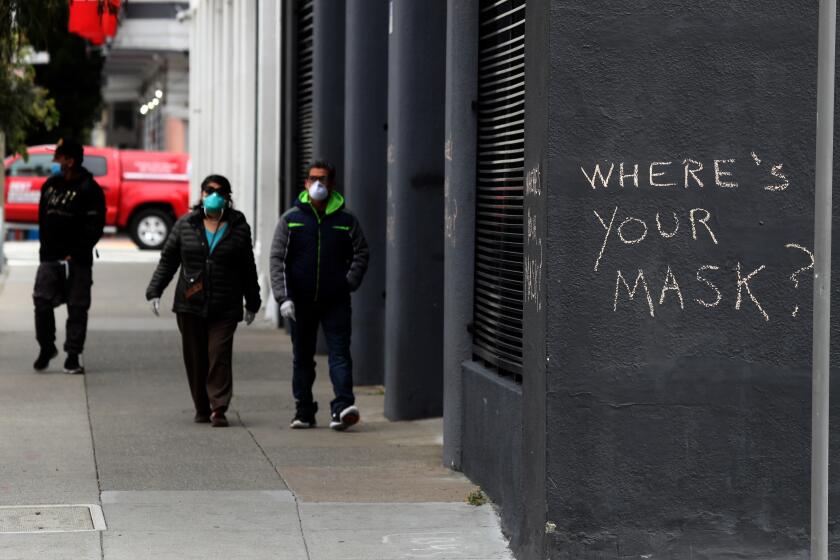 SAN FRANCISCO, CALIFORNIA - APRIL 20: Pedestrians walk by graffiti encouraging the wearing of masks on April 20, 2020 in San Francisco, California. Counties in the San Francisco Bay Area have announced that people must wear masks when in public or at the workplace in an effort to slow the spread of coronavirus COVID-19. (Photo by Justin Sullivan/Getty Images)