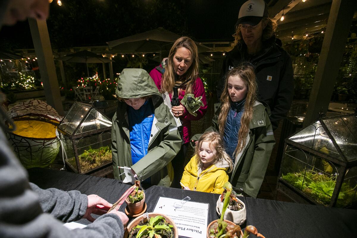Michelle and Brian Rayner, with Dax, Sunny and Maryn, check out carnivorous plants at Creatures of the Night Friday. 
