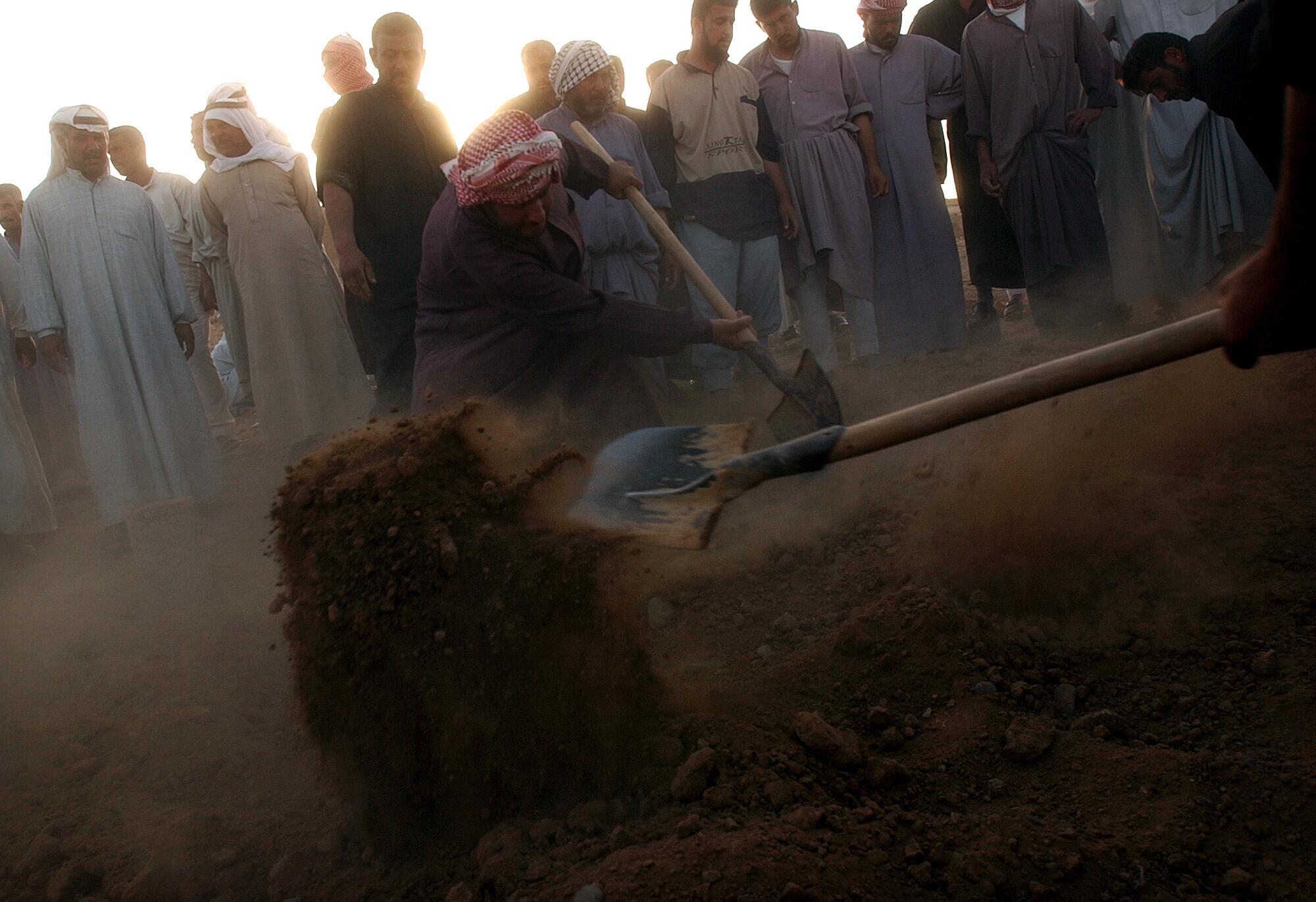 Dirt is shoveled onto the grave of Iraqi Republican Guard soldier Saadi Hamid Hussein, 32.