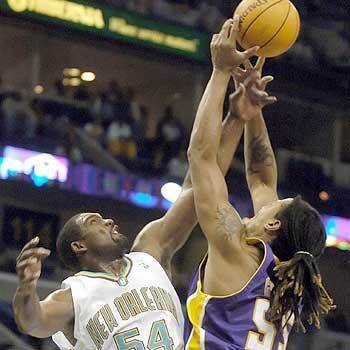 New Orleans Hornets' Rodney Rogers and Los Angeles Lakers' Brian Grant battle for a loose ball in New Orleans.