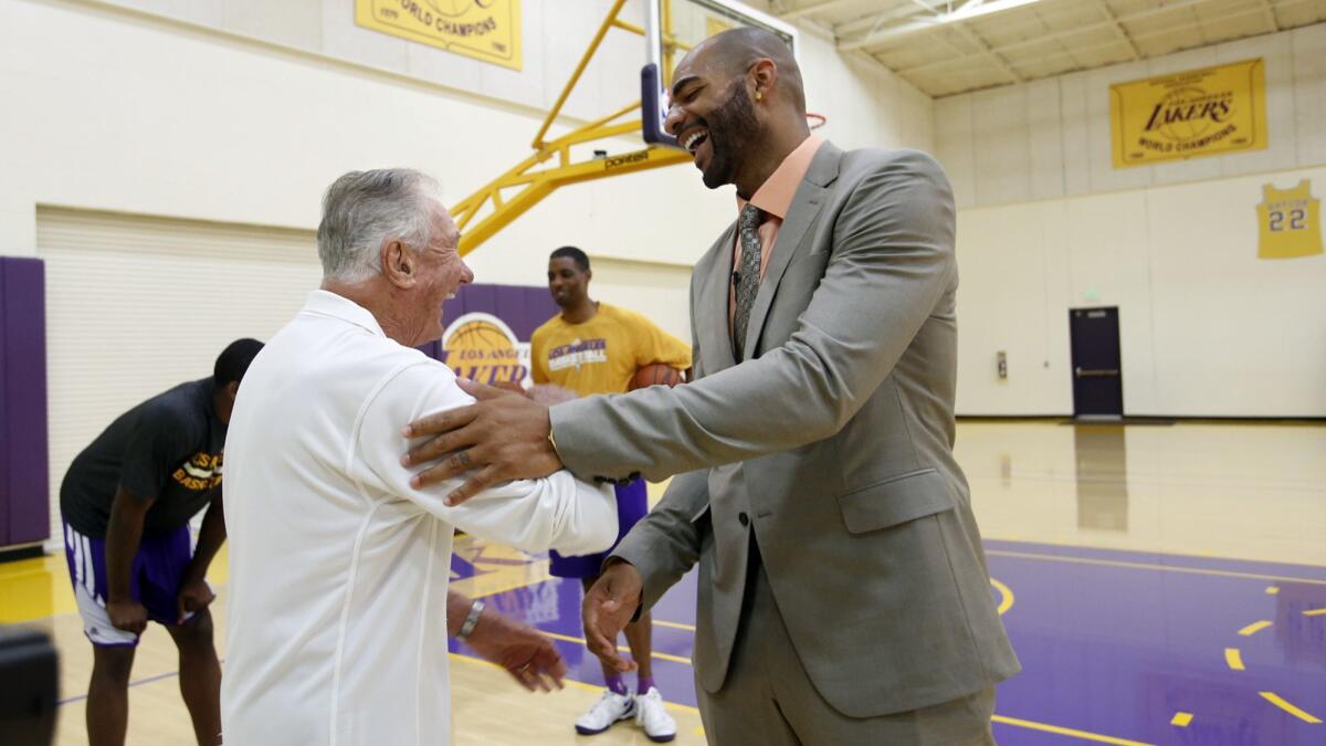 Bill Bertka, left, basketball consultant for the Lakers, greets Lakers forward Carlos Boozer, after a press conference at he Lakers practice facility in El Segundo on July 25, 2014.