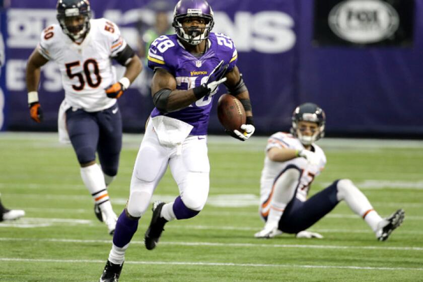 Vikings running back Adrian Peterson breaks into the clear past Bears defenders James Anderson (50) and Chris Conte on Sunday.
