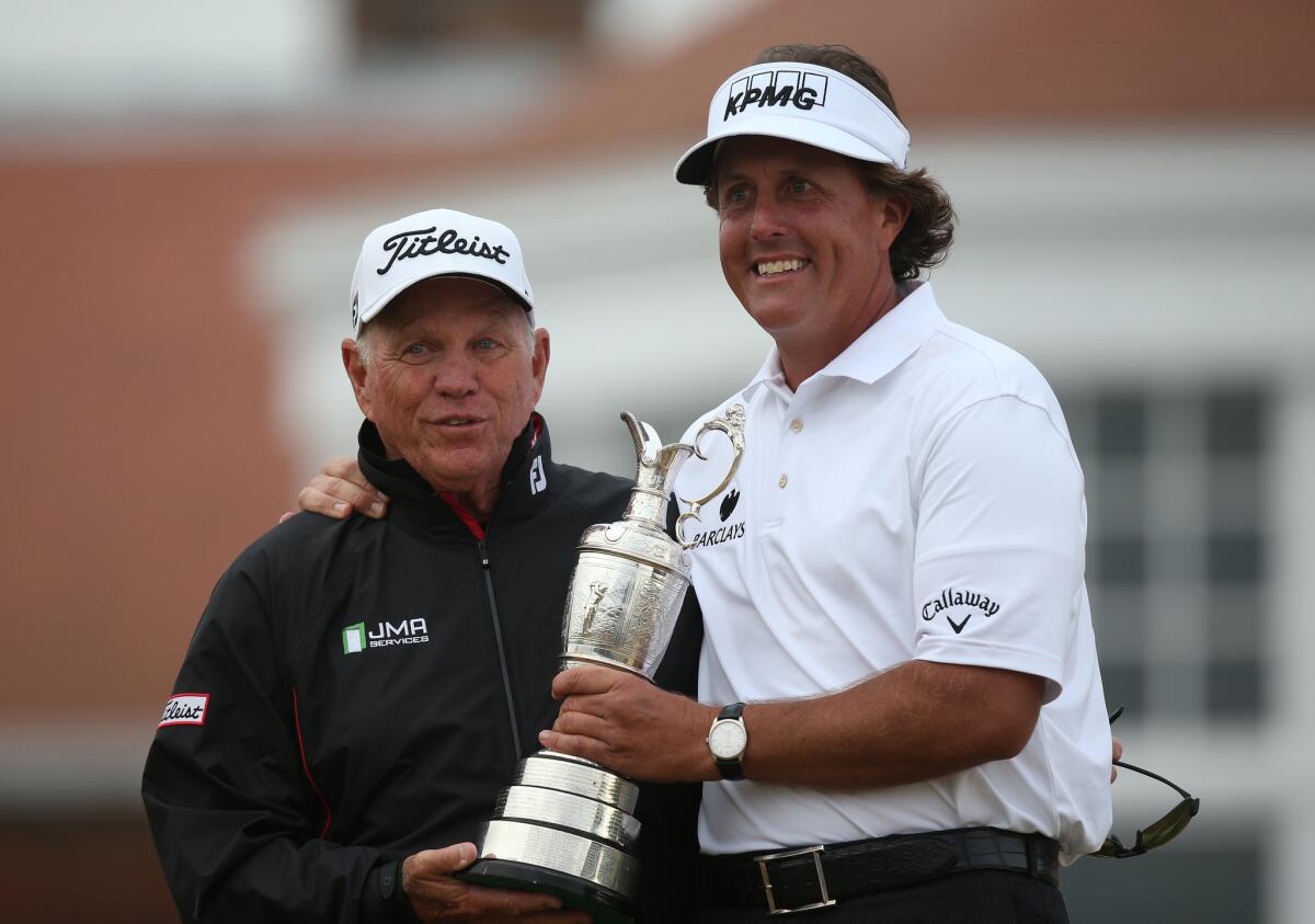 Phil Mickelson poses for pictures with his coach Butch Harmon and his trophy the Claret Jug after winning the 2013 British Open Golf Championship.