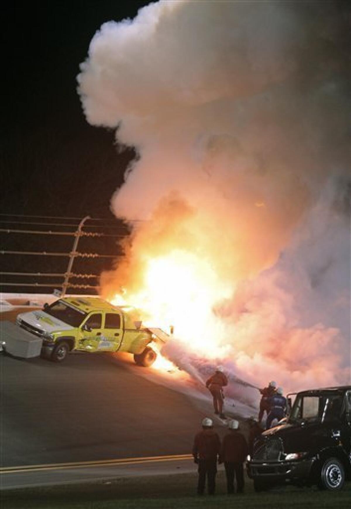 Emergency workers try to put out a fire on a jet dryer during the NASCAR Daytona 500 auto race at Daytona International Speedway in Daytona Beach, Fla., Monday, Feb. 27, 2012. (AP Photo/Bill Friel)