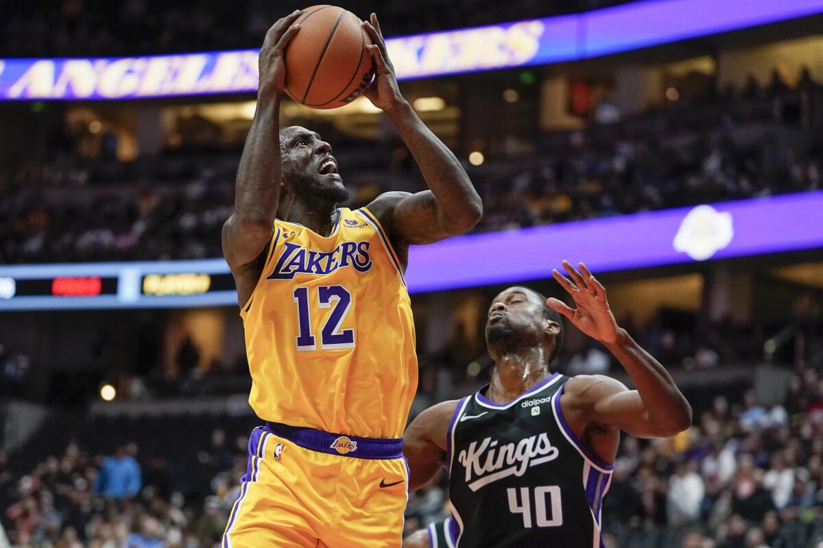 The Lakers' Taurean Prince shoots past Sacramento Kings forward Harrison Barnes in a preseason game.
