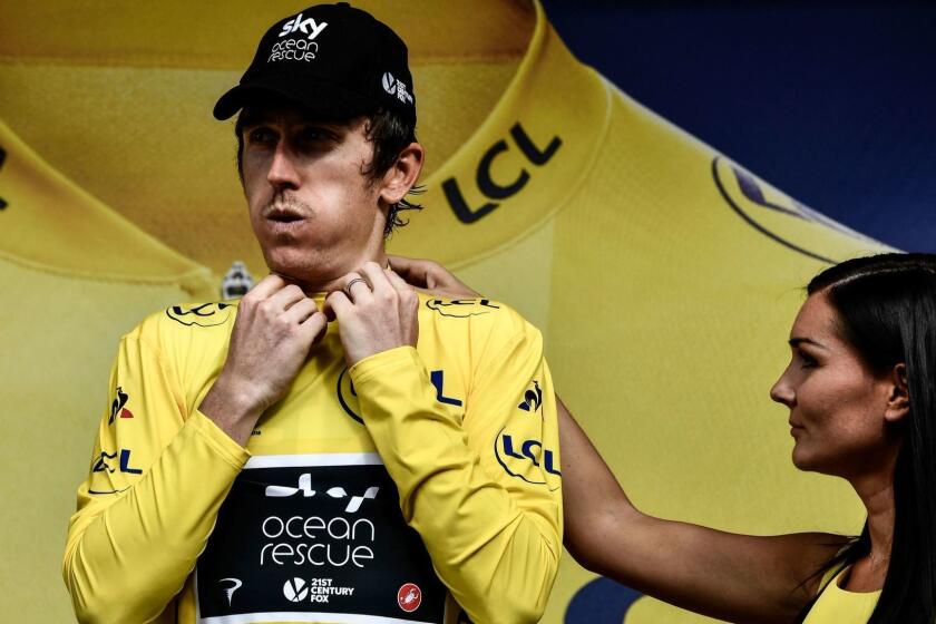 Great Britain's Geraint Thomas puts on the overall leader's yellow jersey on the podium after the 19th stage of the 105th edition of the Tour de France cycling race, on July 27, 2018 between Lourdes and Laruns, southwestern France. / AFP PHOTO / Philippe LOPEZPHILIPPE LOPEZ/AFP/Getty Images ** OUTS - ELSENT, FPG, CM - OUTS * NM, PH, VA if sourced by CT, LA or MoD **