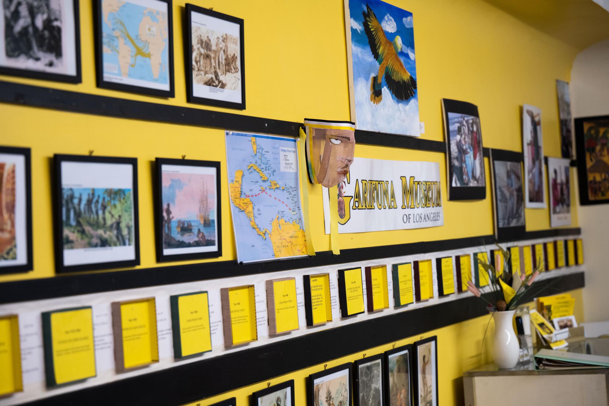A museum wall with pictures, maps and text.