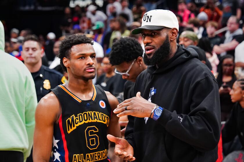 LeBron James talks with his son, Bronny, on the sidelines of the McDonald's All-American game