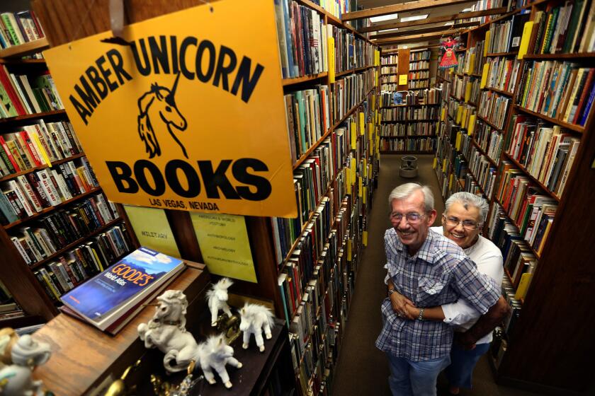 Lou and Myrna Donato, owners of Amber Unicorn Books, pose among the many books in their store.