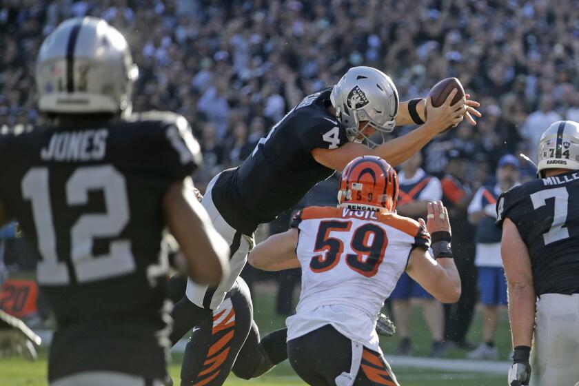 Raiders quarterback Derek Carr leaps across the goal line to score a three-yard touchdown against the Bengals on Nov. 17, 2019, in Oakland.