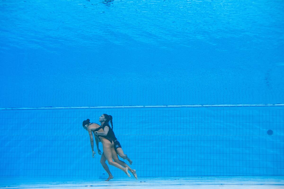A woman rescues an unconscious swimmer from the bottom of the pool. 