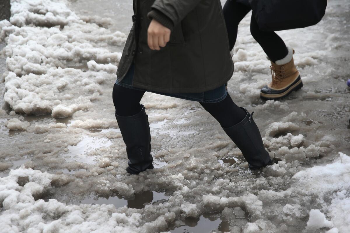 People navigate a slushy intersection near New York City's Union Square on Wednesday. Millions of Americans in the Midwest and Northeast dealt with the latest winter storm.