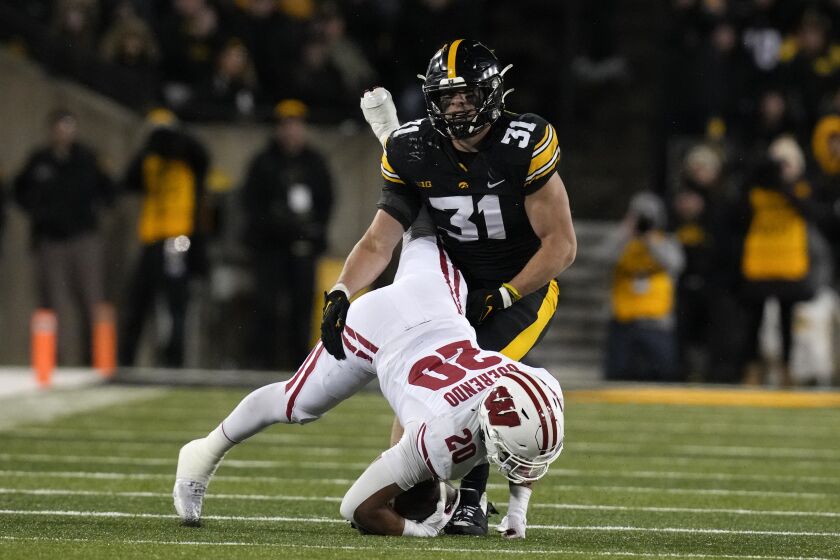 Wisconsin running back Isaac Guerendo (20) is tackled by Iowa linebacker Jack Campbell (31) after catching a pass during the second half of an NCAA college football game, Saturday, Nov. 12, 2022, in Iowa City, Iowa. Iowa won 24-10. (AP Photo/Charlie Neibergall)