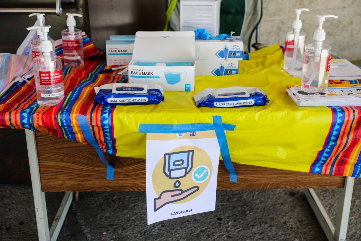 Hand sanitizer, wipes and masks on a table.