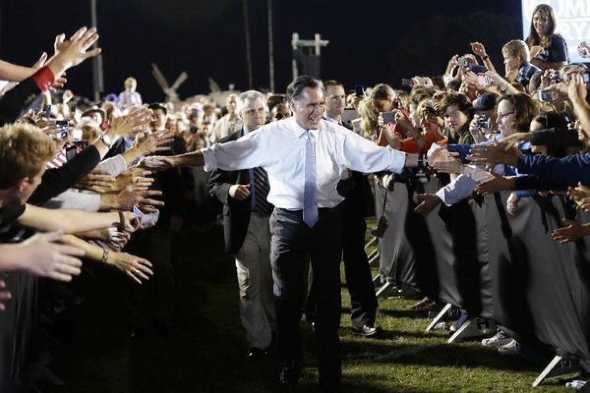 Mitt Romney reaches out to supporters as he campaigns on the football field at Land O'Lakes High School in Land O'Lakes, Fla.