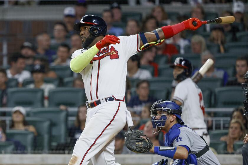 The Braves' Marcell Ozuna watches his two-run, eighth-inning homer June 25, 2022. Dodgers catcher Austin Barnes is at right.
