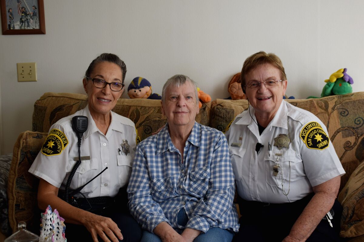 Through the county's You Are Not Alone program, senior volunteers like Paula Saltz (left) and Marie Allin (right) regularly check in with homebound people living alone. Saltz and Allin pose with YANA member Dorothy during a visit on Dec. 9.