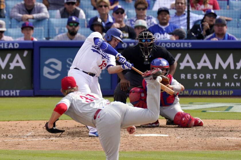 Los Angeles Dodgers' Max Muncy, second from left, hits a walk-off grand slam as Philadelphia Phillies relief pitcher Craig Kimbrel, left, watches along with catcher Garrett Stubbs, right, and home plate umpire Edwin Moscoso during the ninth inning of a baseball game Wednesday, May 3, 2023, in Los Angeles. The Dodgers won 10-6. (AP Photo/Mark J. Terrill)