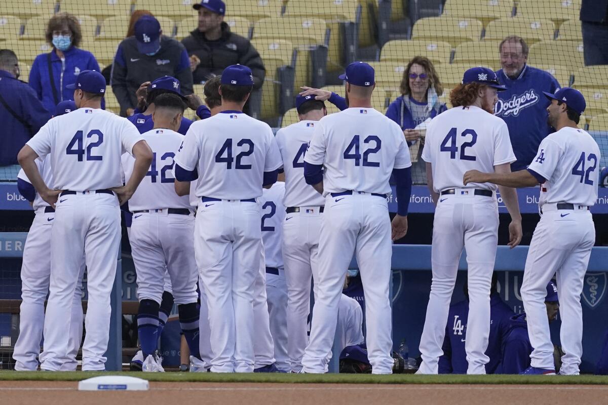 The Los Angeles Dodgers enter the dugout before their baseball game against the Colorado Rockies.