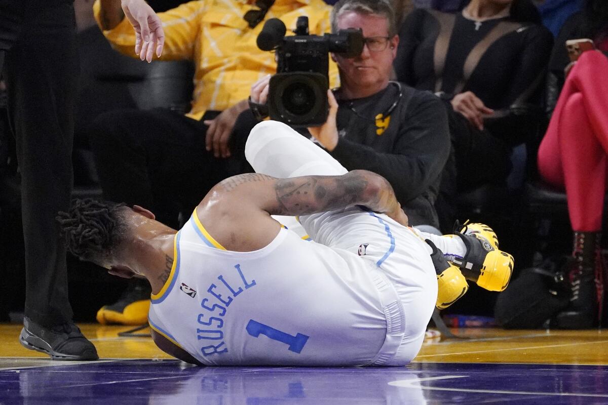 Lakers point guard D'Angelo Russell writhes on the court after injuring his right ankle Thursday.