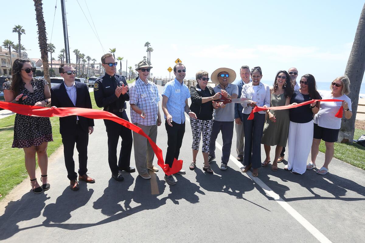 City officials and dignitaries hold a ribbon-cutting ceremony Monday officially opening Bluff Top Park in Huntington Beach. 