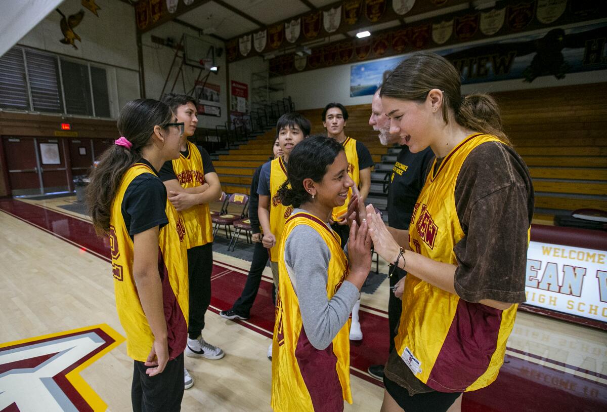 Members of the Ocean View Unified basketball team, Mirna Metry, center, and Lily Campbell, high five.