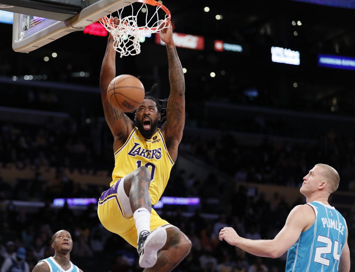 Lakers center DeAndre Jordan hangs on the rim after dunking against the Hornets.