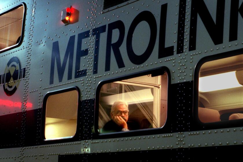 Metrolink rider looks out window as train pulls into the Santa Ana Transportation Center.