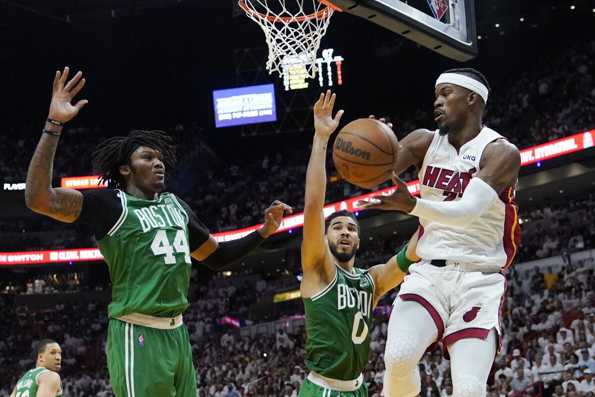 Boston Celtics center Robert Williams III and forward Jayson Tatum attempt to block a pass by the Heat's Jimmy Butler.