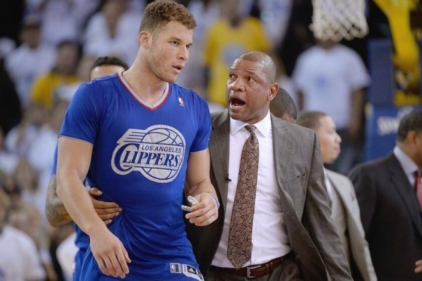 Clippers Coach Doc Rivers escorts power forward Blake Griffin off the court after he was ejected for drawing a second technical foul in a Dec. 25 game against the Warriors.