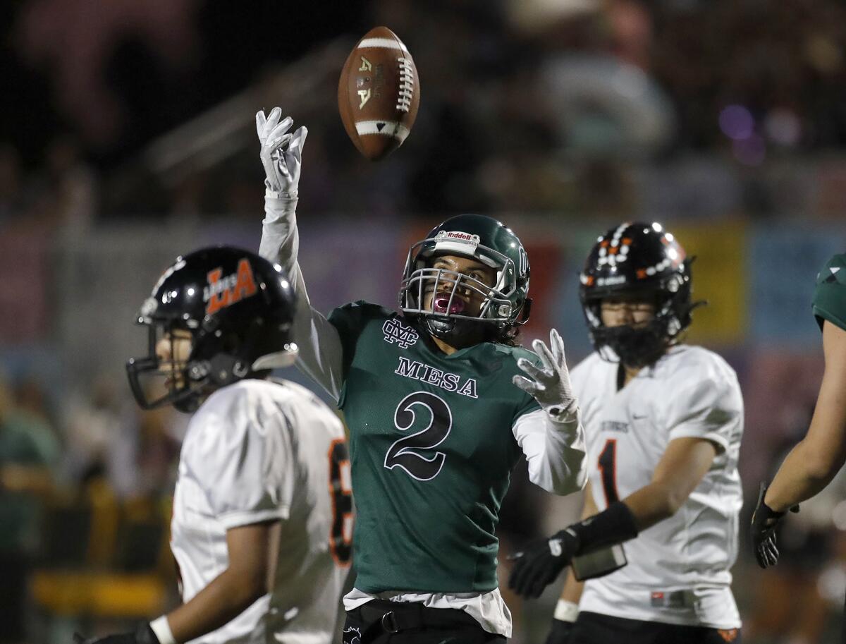 Costa Mesa's Kendrick Figueroa spins the ball in the air after a short touchdown run against Los Amigos on Friday.