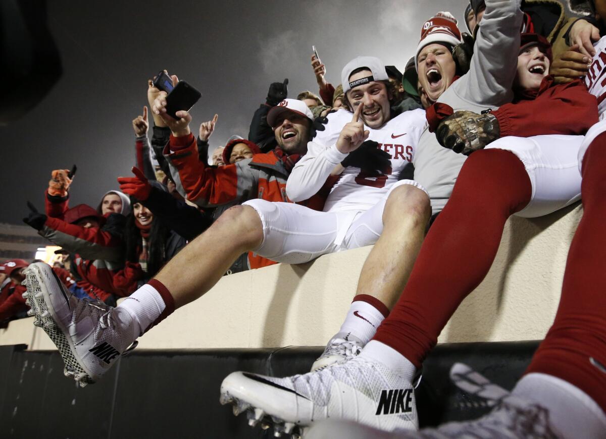 Quarterback Baker Mayfield, center, and the Oklahoma Sooners are sitting in the cat bird's seat while three other teams should get into the College Football Playoff with wins this weekend.