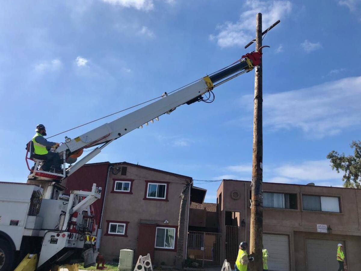 A San Diego Gas & Electric crew removes an above-ground utility pole in Sherman Heights in September 2019. 