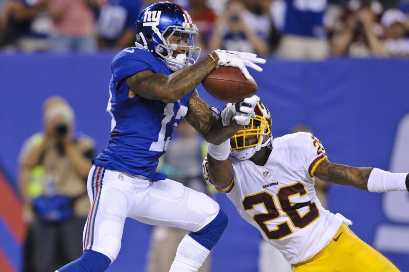 Giants wide receiver Odell Beckham Jr. (13) catches a pass for a touchdown in front of Redskins cornerback Bashaud Breeland (26) in the second half Thursday night at MetLife Stadium.