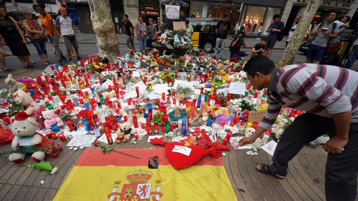 A man places a candle to pay tribute to victims of the attack on Las Ramblas boulevard in Barcelona.